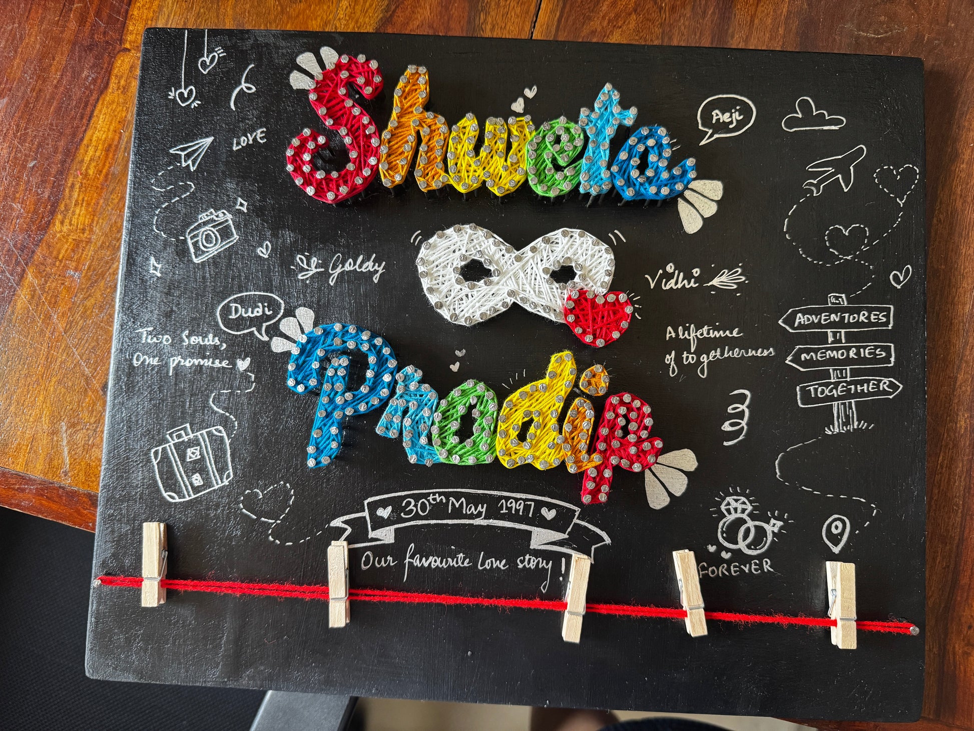 Decorative board with colorful letters and symbols on a wooden surface